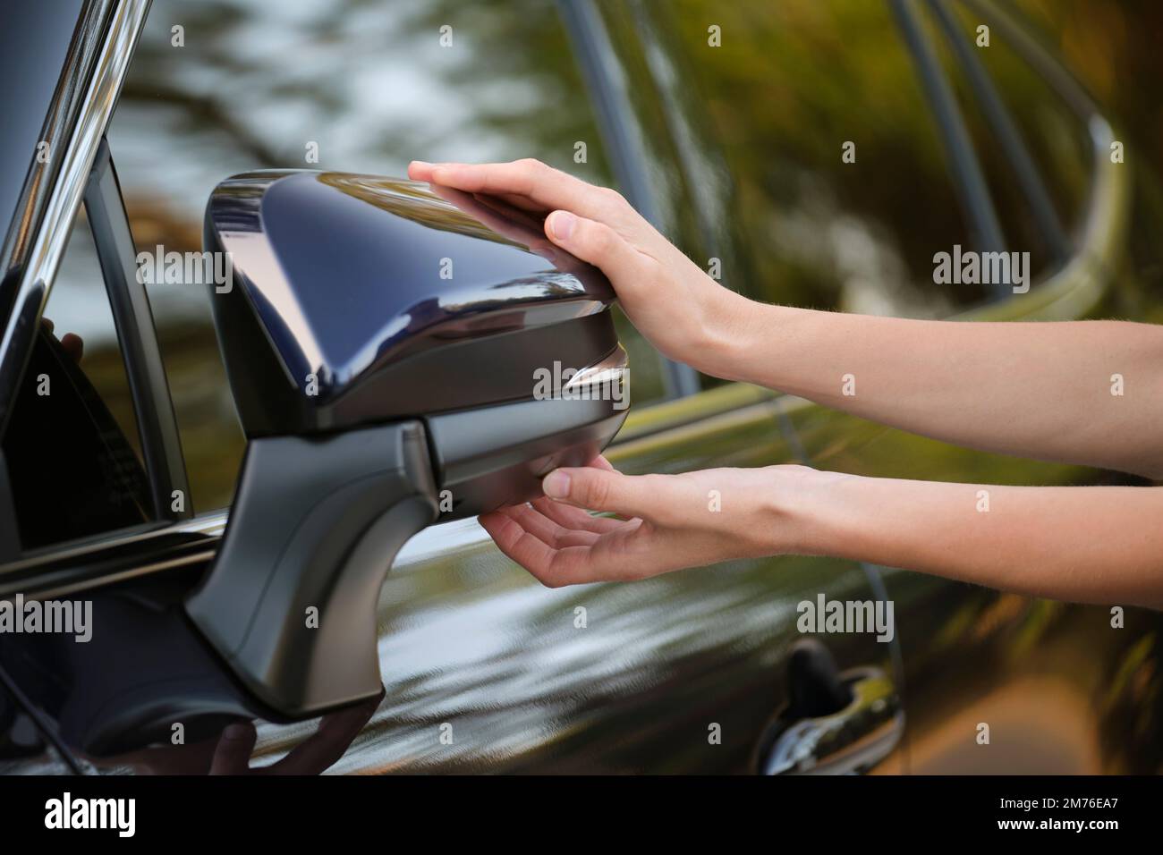 Driver hands adjusting side view mirror of a car Stock Photo Alamy