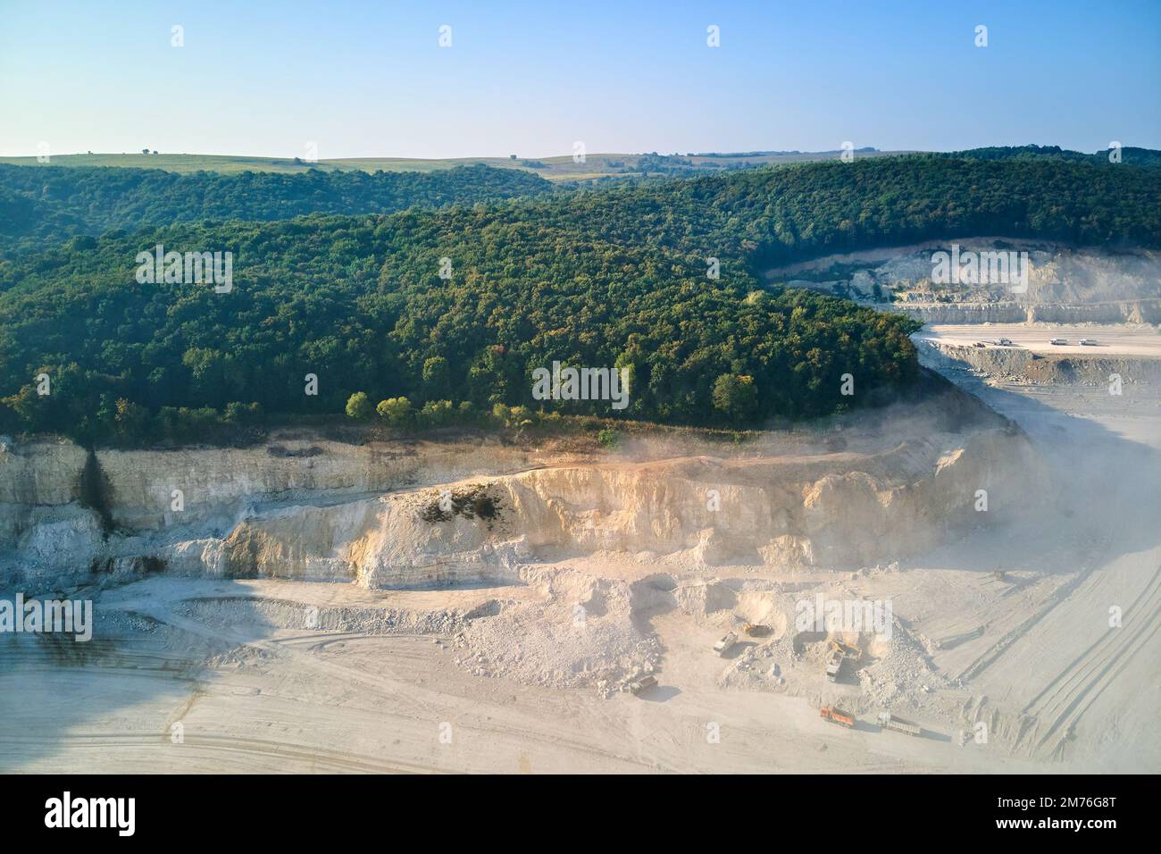 Aerial view of open pit mining site of limestone materials extraction for construction industry with excavators and dump trucks Stock Photo