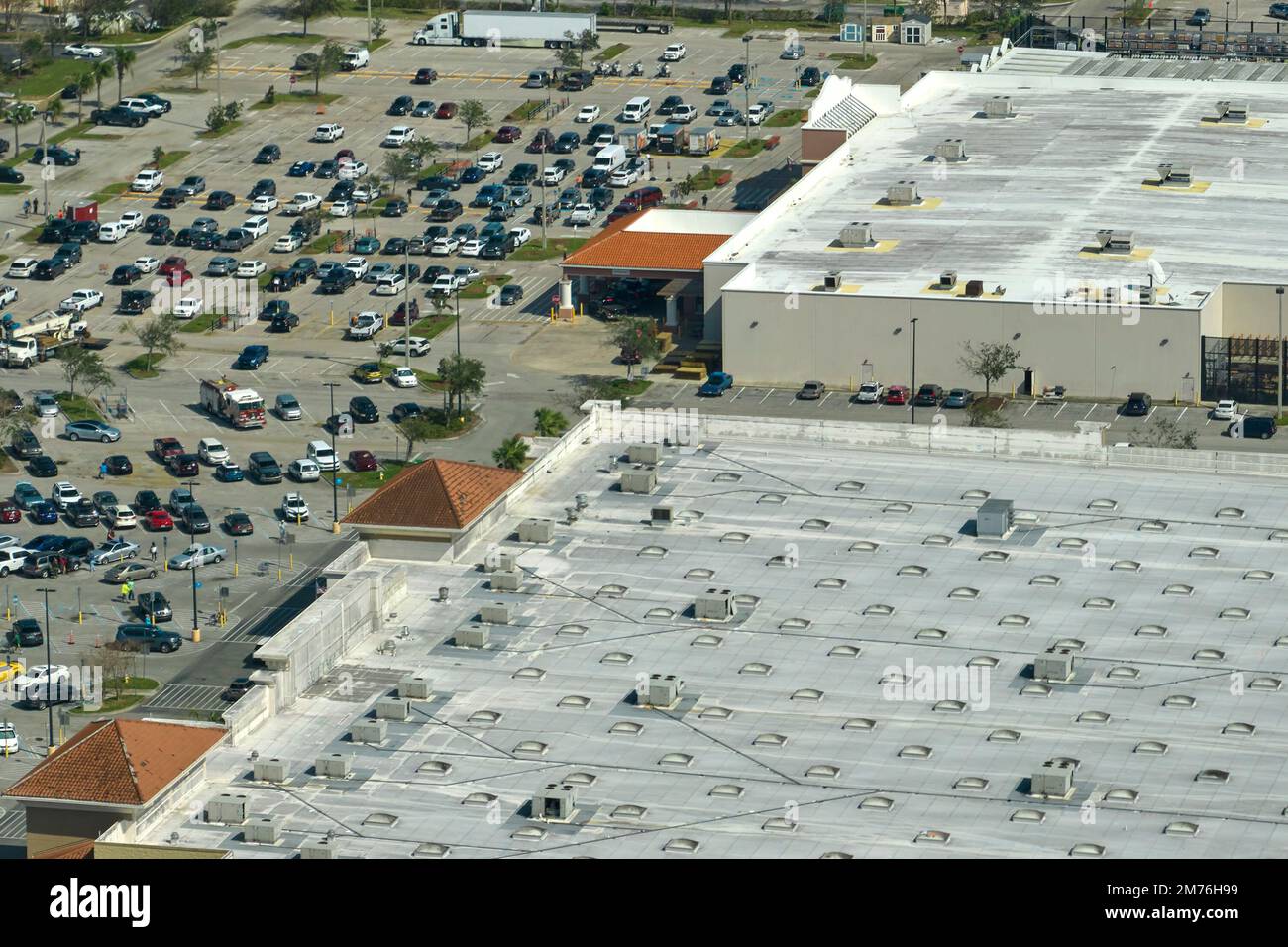 View from above of american grocery store with many parked cars on parking lot with lines and markings for parking places and directions. Place for Stock Photo