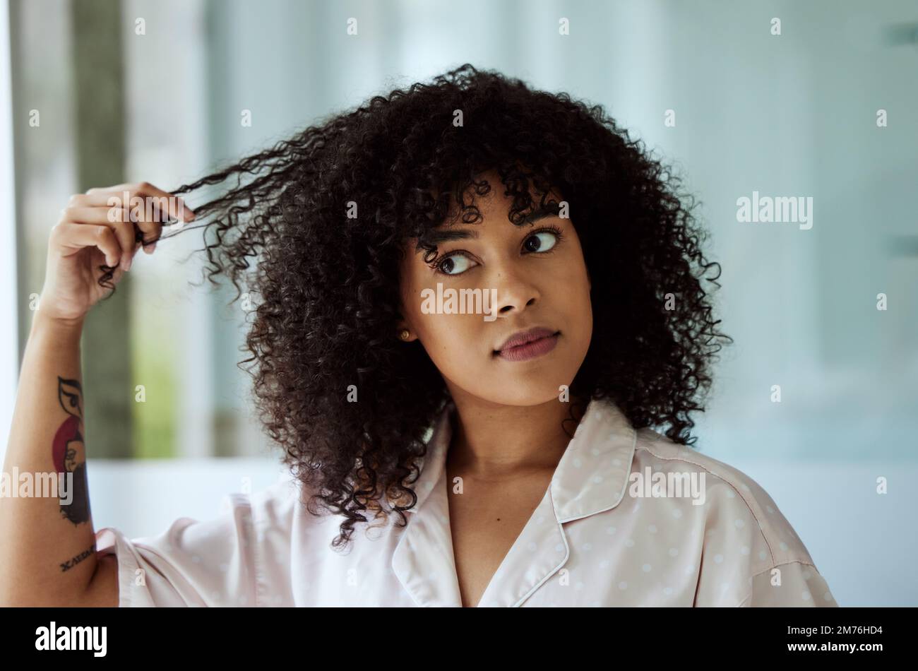 Morning, natural and black woman with hair care bathroom routine feeling curly hair texture. Beauty, self care and african girl thinking of cosmetic Stock Photo