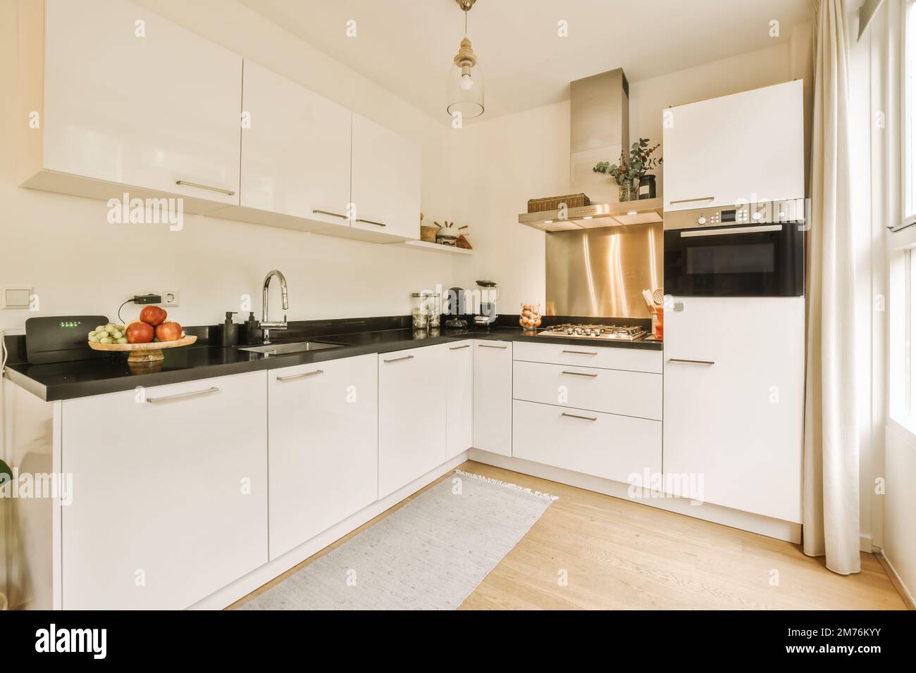 a kitchen with white cupboards and black counter tops on the counters in this room is very clean, but it's not Stock Photo