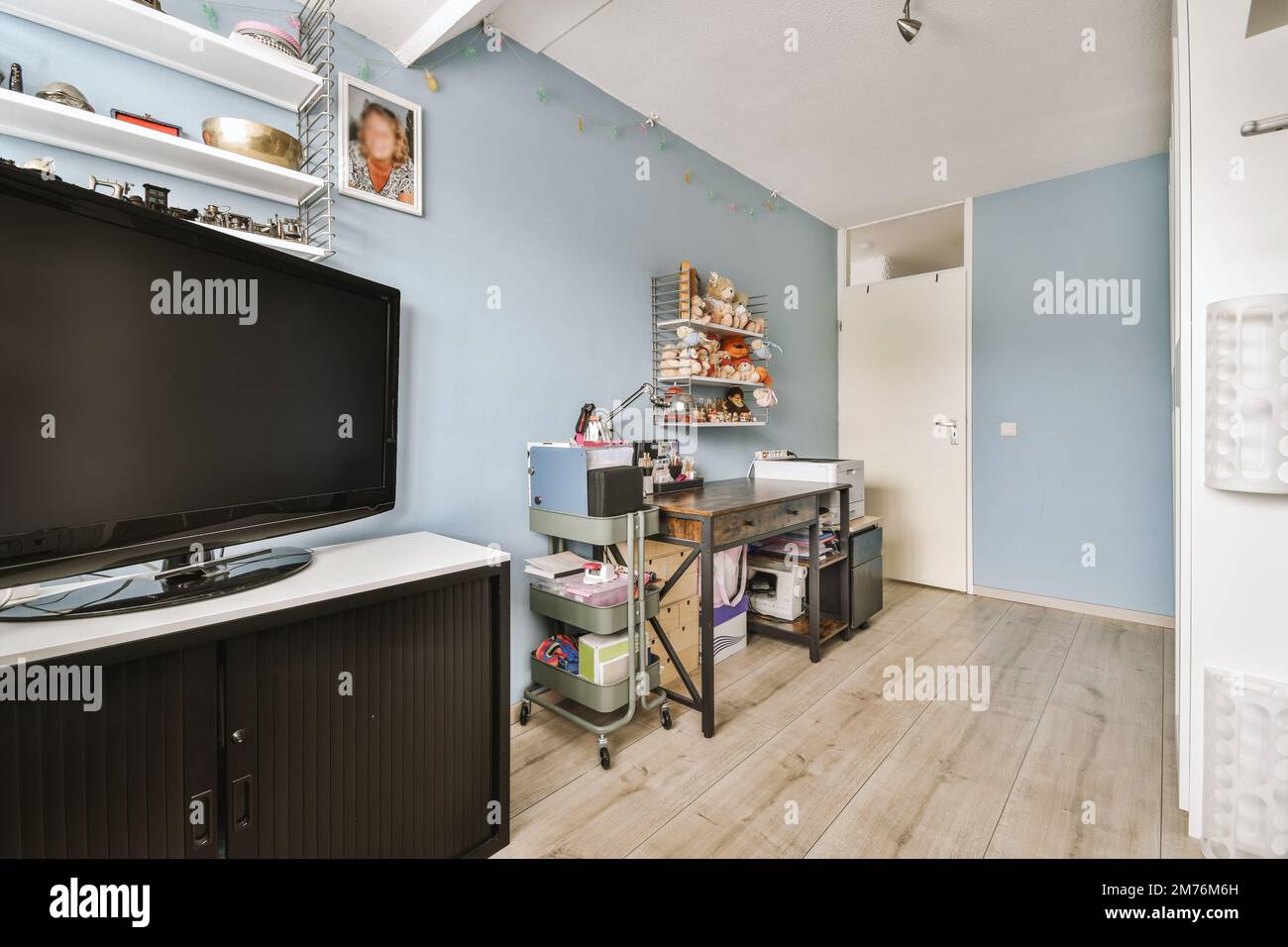 a living room with a flat screen tv on the wall and wooden flooring in