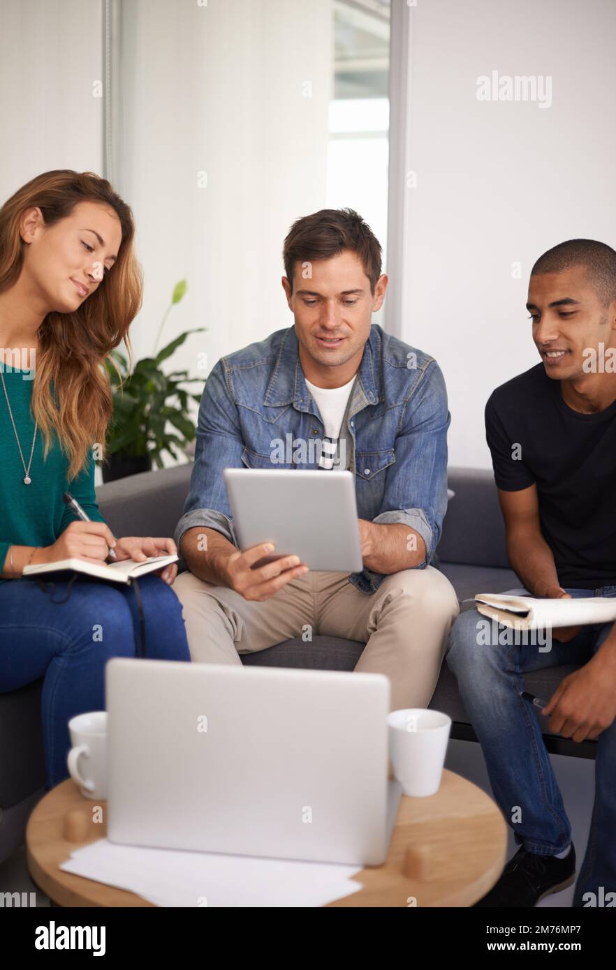 Taking notes. a team of young business professionals in an informal meeting. Stock Photo