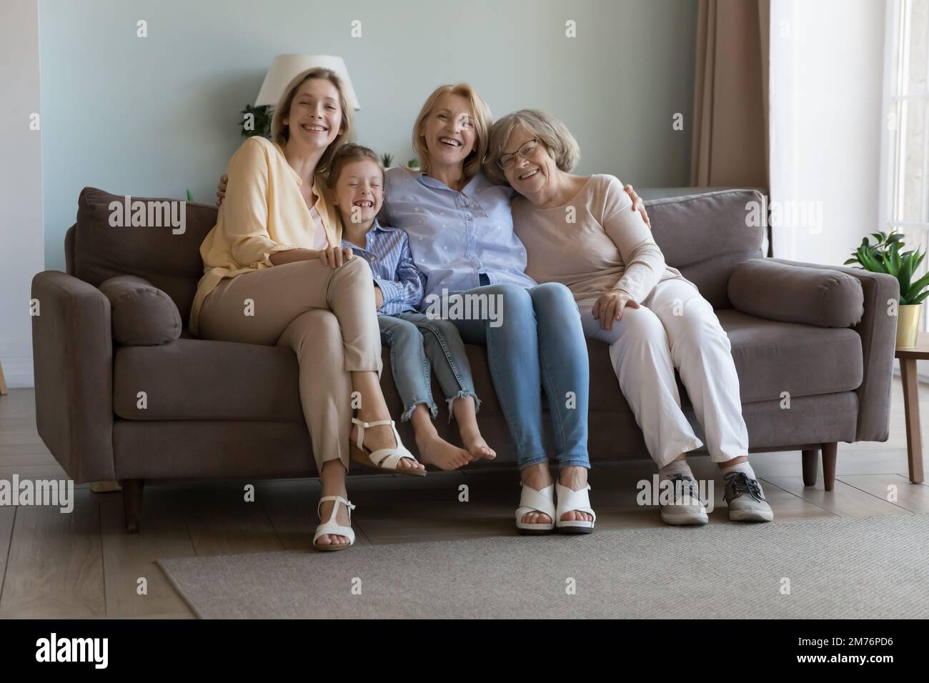 Cheerful cute girls and women of four family generations Stock Photo