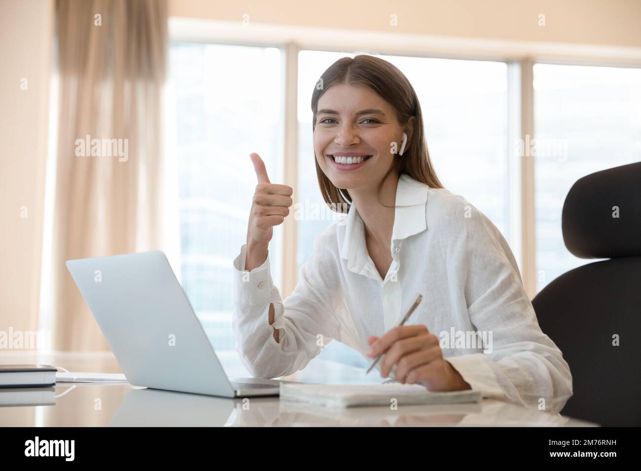 Woman student e-learns online smile showing thumbs up gesture Stock Photo