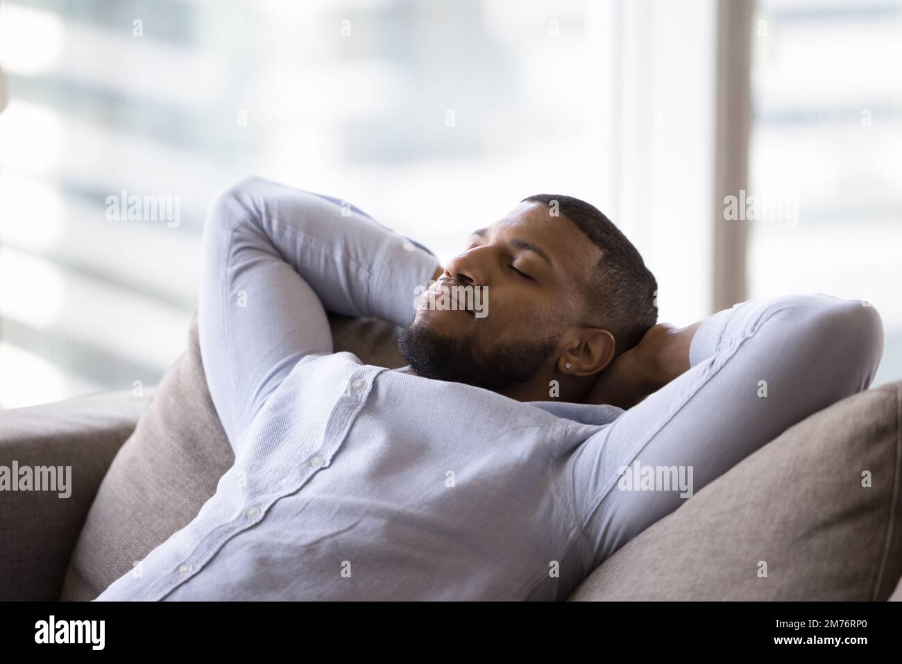 Man Rest Calm African man rest leaned on soft sofa cushions Stock Photo - Alamy