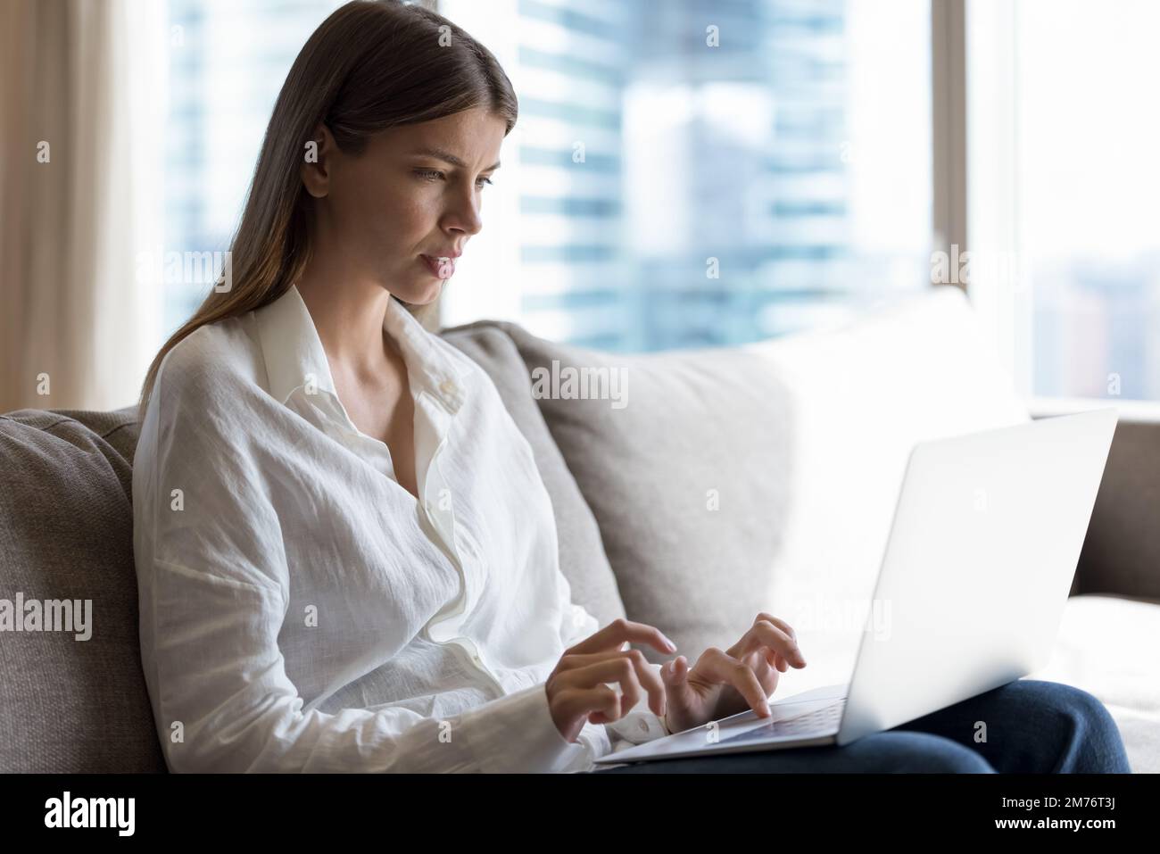 Attractive young woman working or studying using laptop Stock Photo