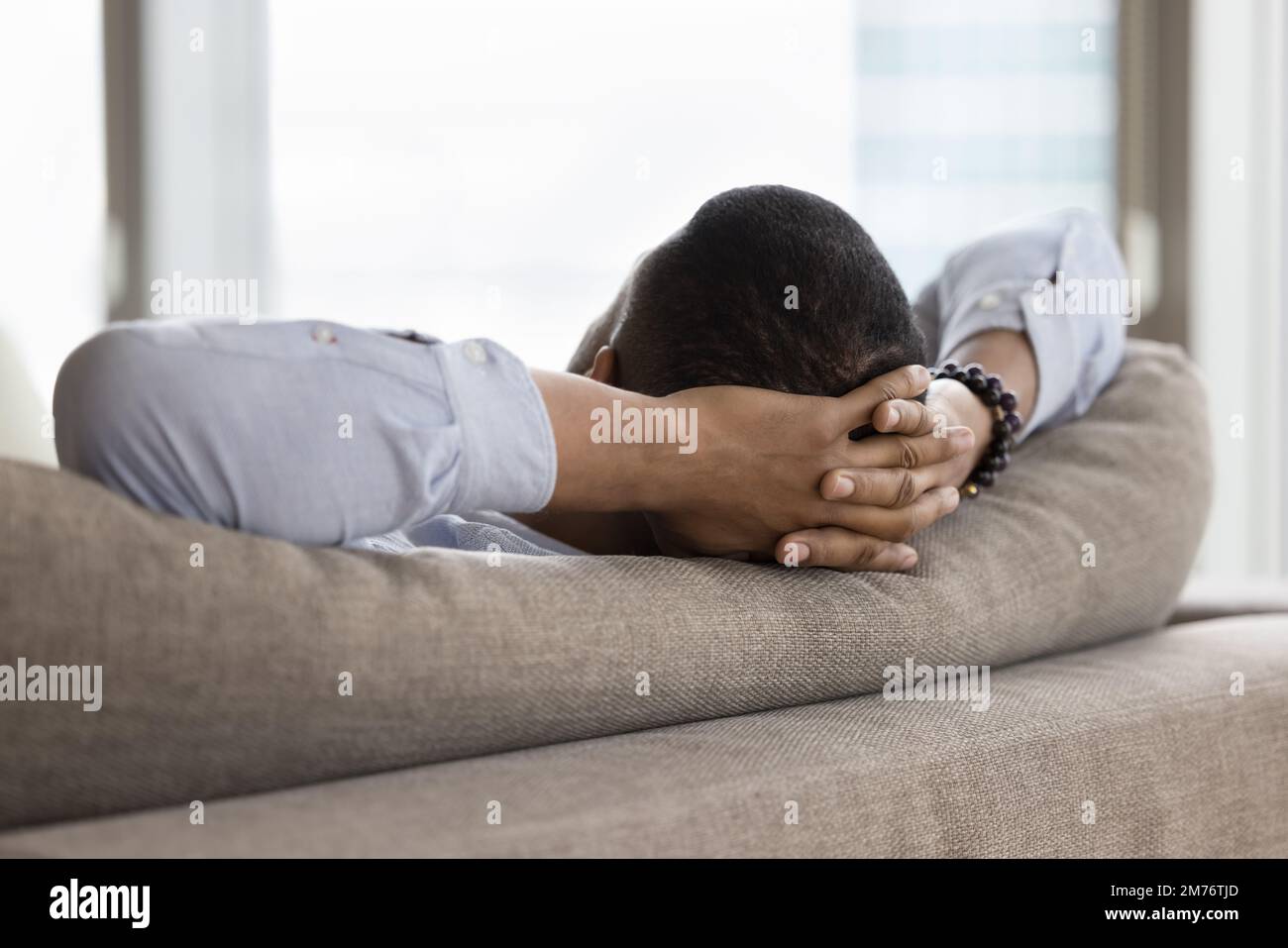 Unknown African single man relaxing leaned on sofa, closeup Stock Photo