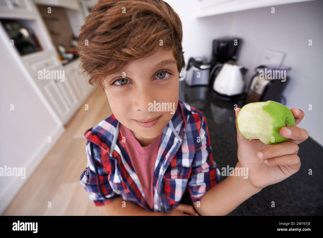 Take it from me, apples are yum. a young boy eating an apple. Stock Photo