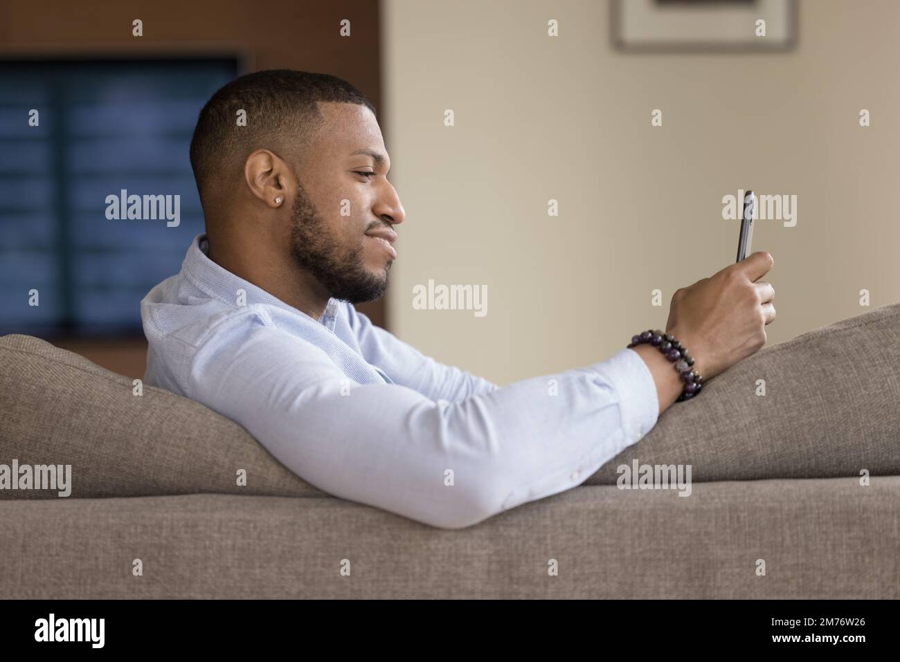 African man resting sit on sofa with smart phone Stock Photo