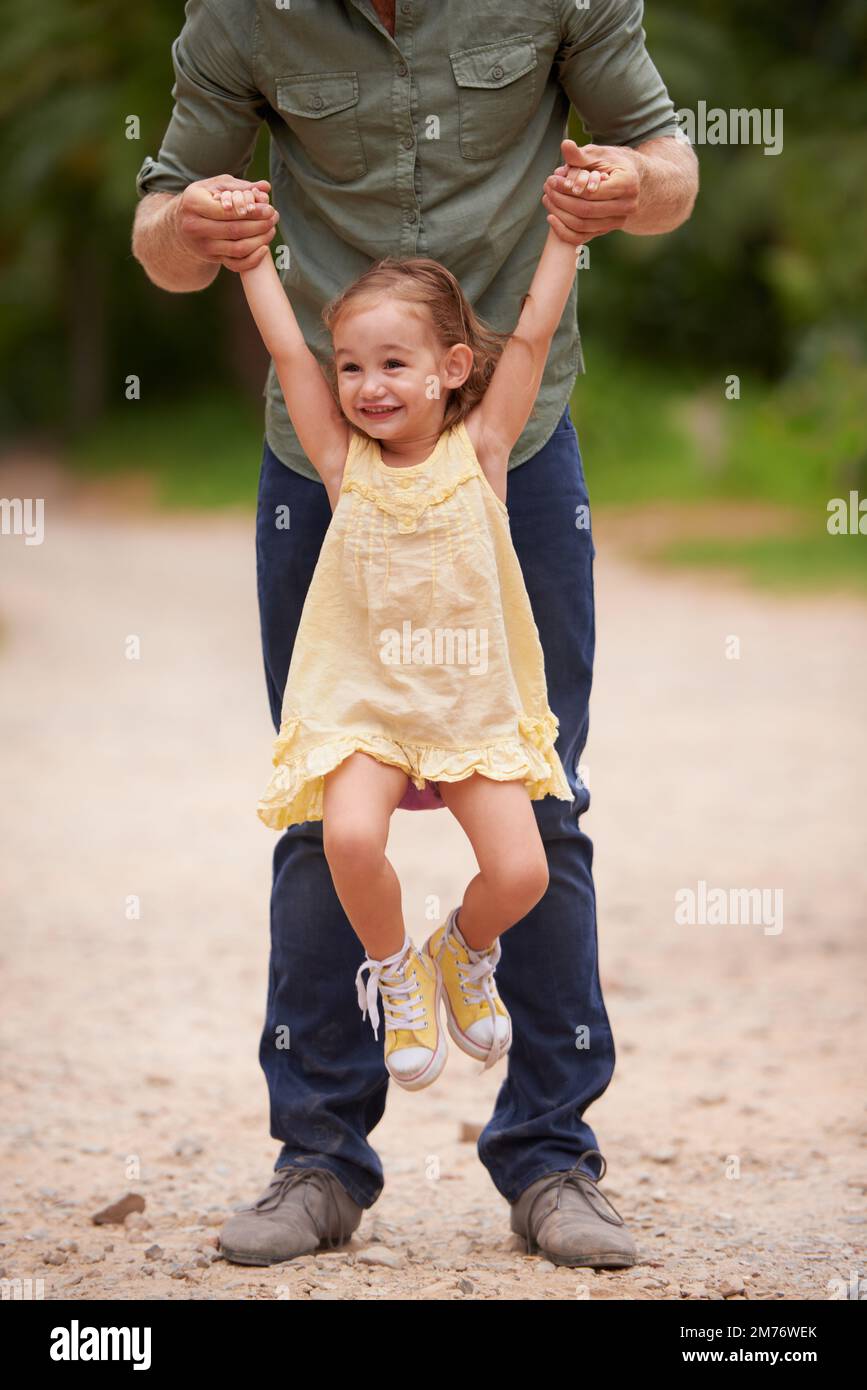 My daddys better than yours. A young girl being lifted up by her dad. Stock Photo