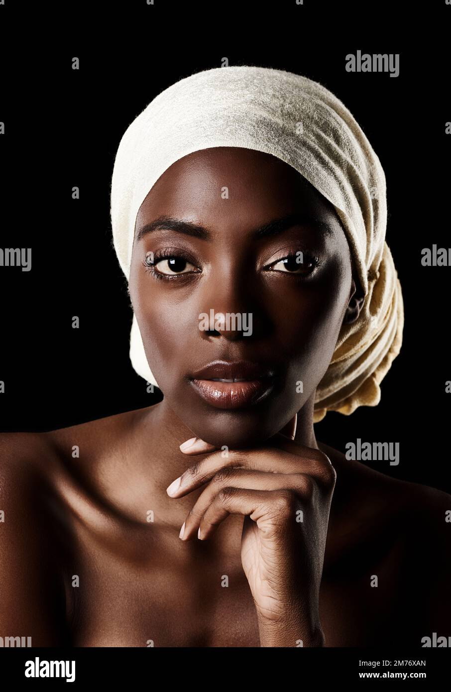 The portrait of beauty. Studio portrait of a beautiful woman wearing a headscarf against a black background. Stock Photo