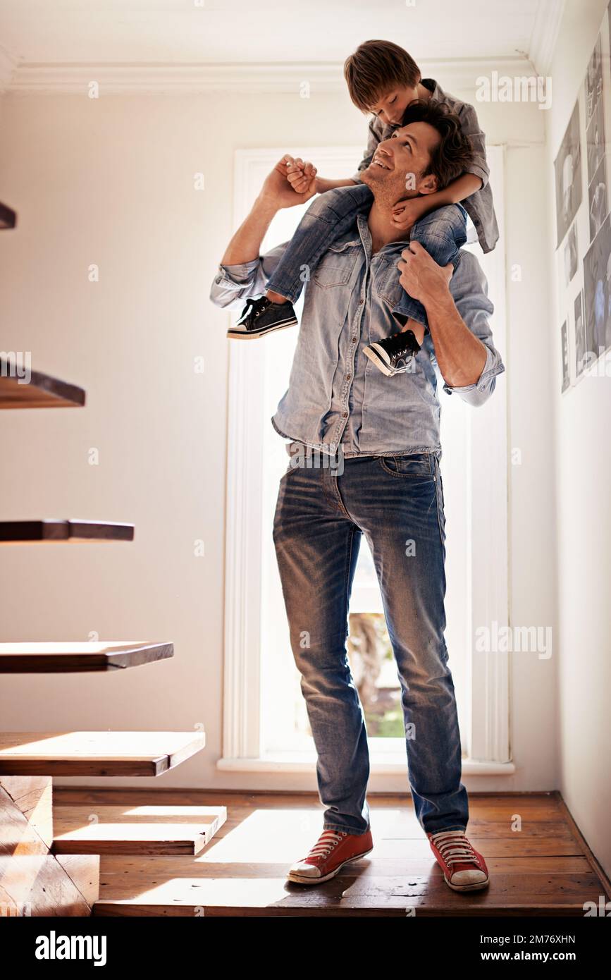 Seeing eye to eye. a father carrying his son on his shoulders at home. Stock Photo