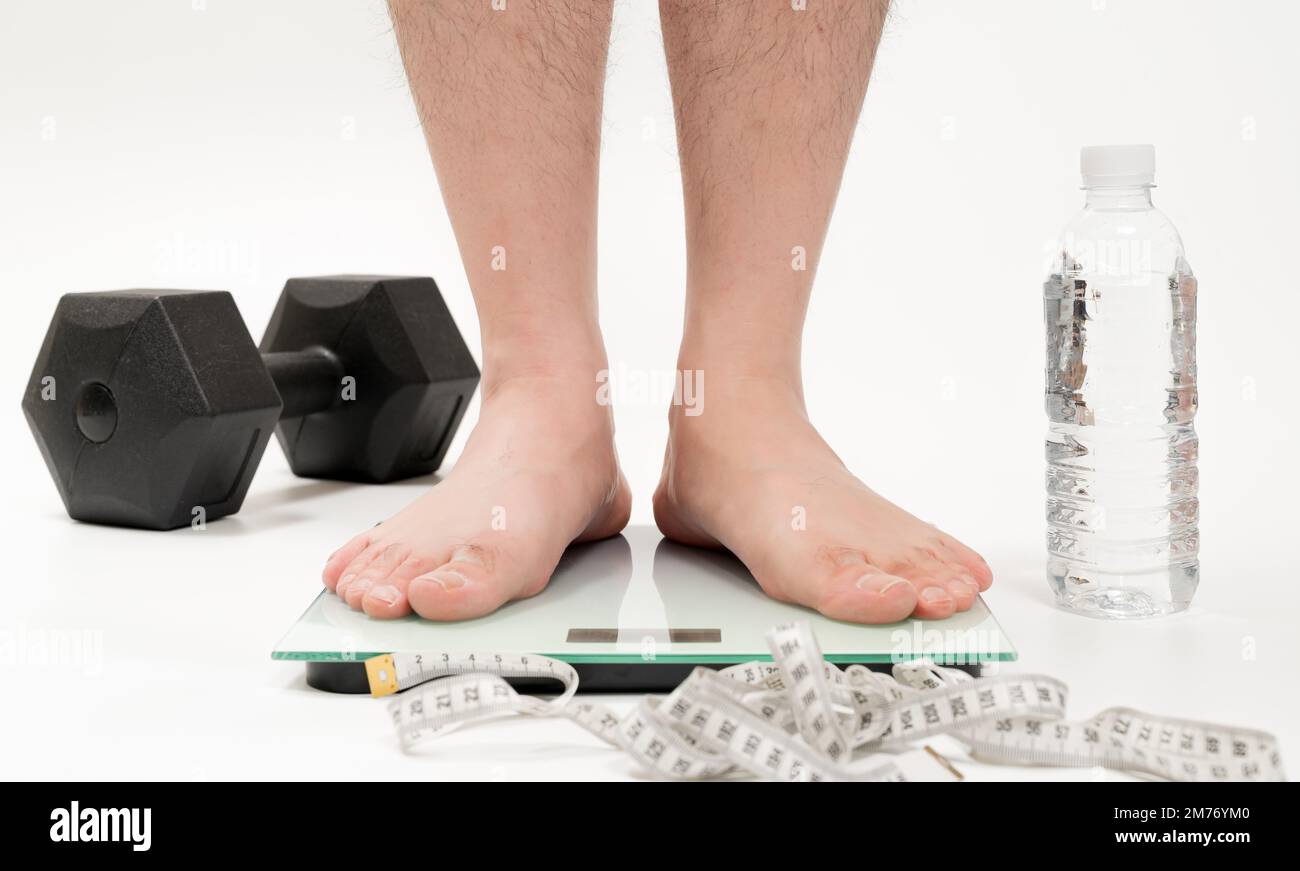 Asian middle-aged man's feet measuring weight Stock Photo