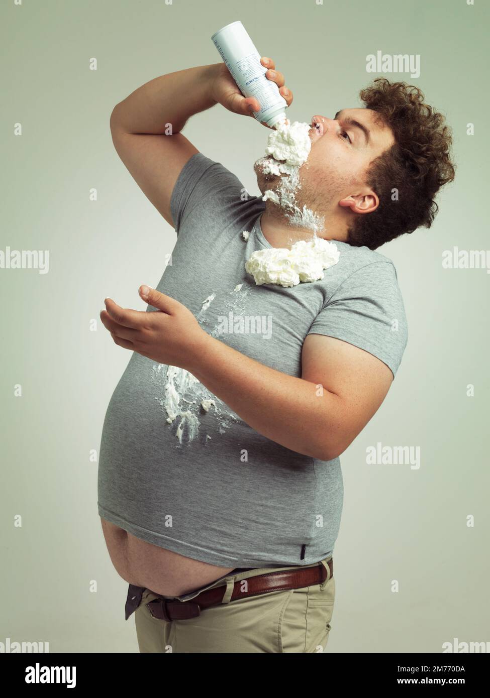 I am the cherry on top. an overweight man filling his mouth with whipped cream. Stock Photo