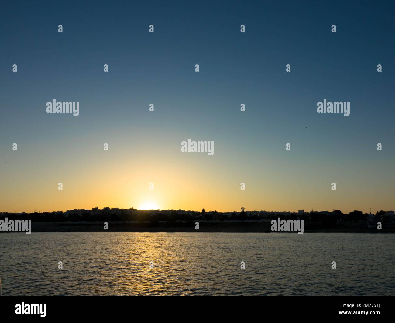 Panoramic view. Sunset over Rhodes town and port. Beautiful sky with space for text. Stock Photo