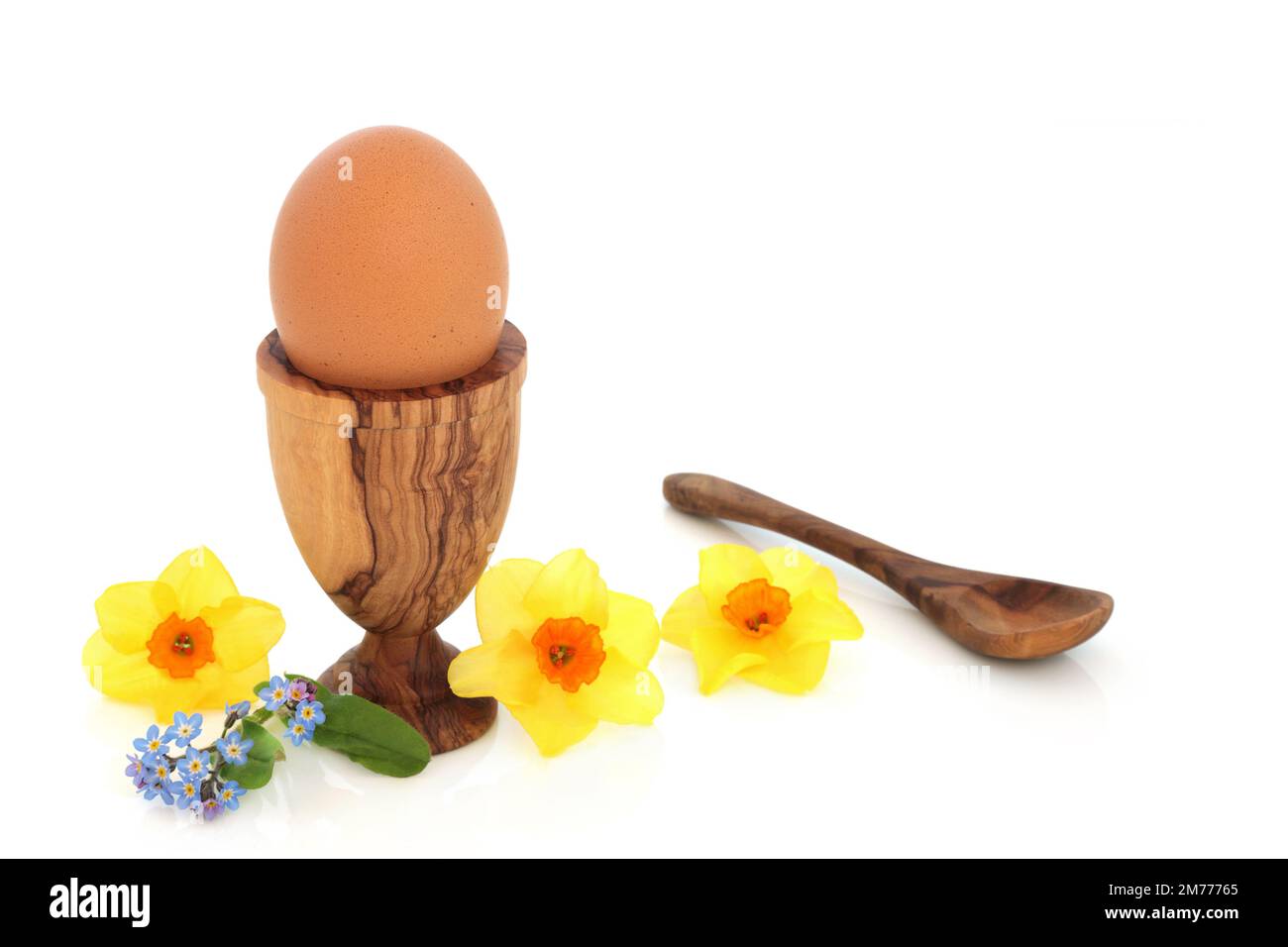 Healthy boiled egg in egg cup with narcissus flowers. Spring, Easter