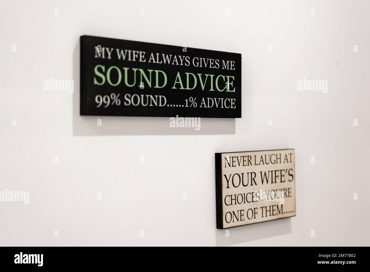 A closeup of funny sayings about wives on the wall Stock Photo