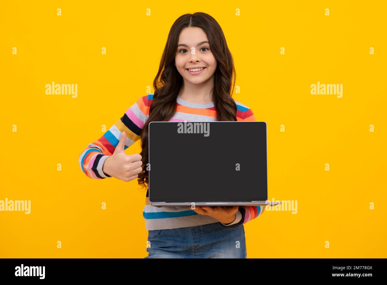 Teenager school girl hold notebook laptop. School children on isolated studio background. Screen