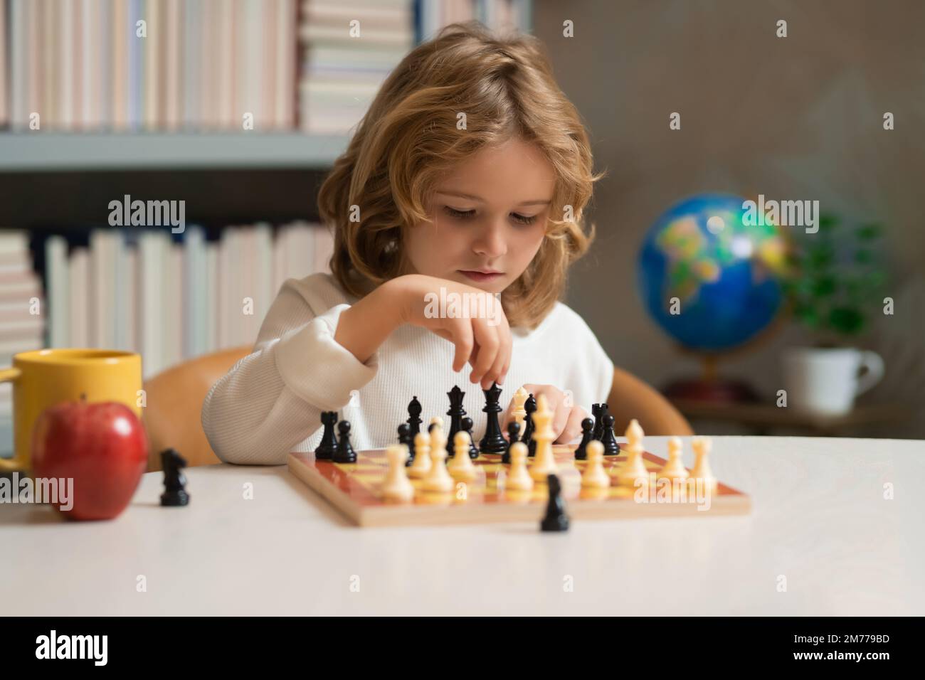 Child boy developing chess strategy, playing board game. Intelligent