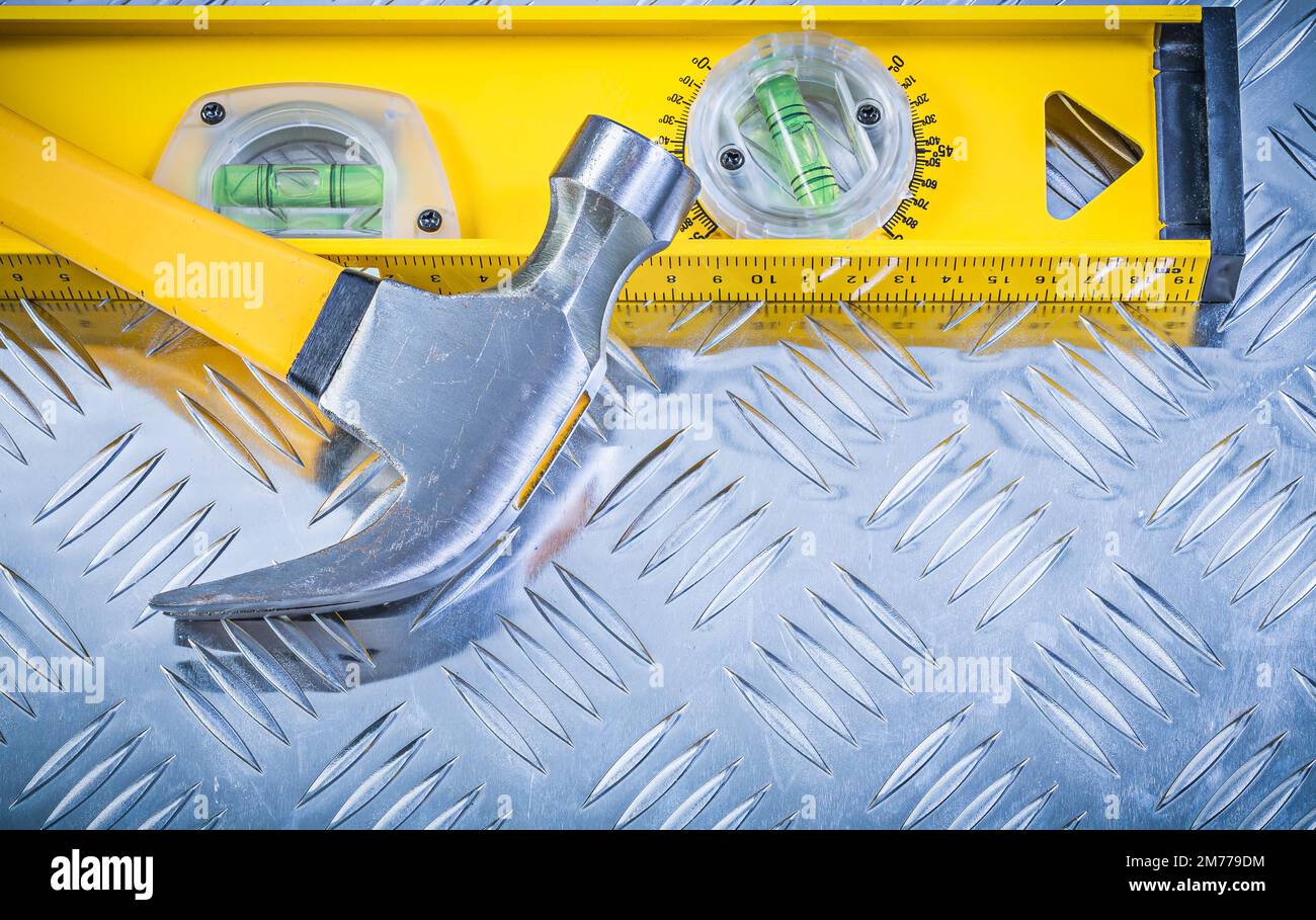 Claw hammer construction level on corrugated metal sheet Stock Photo