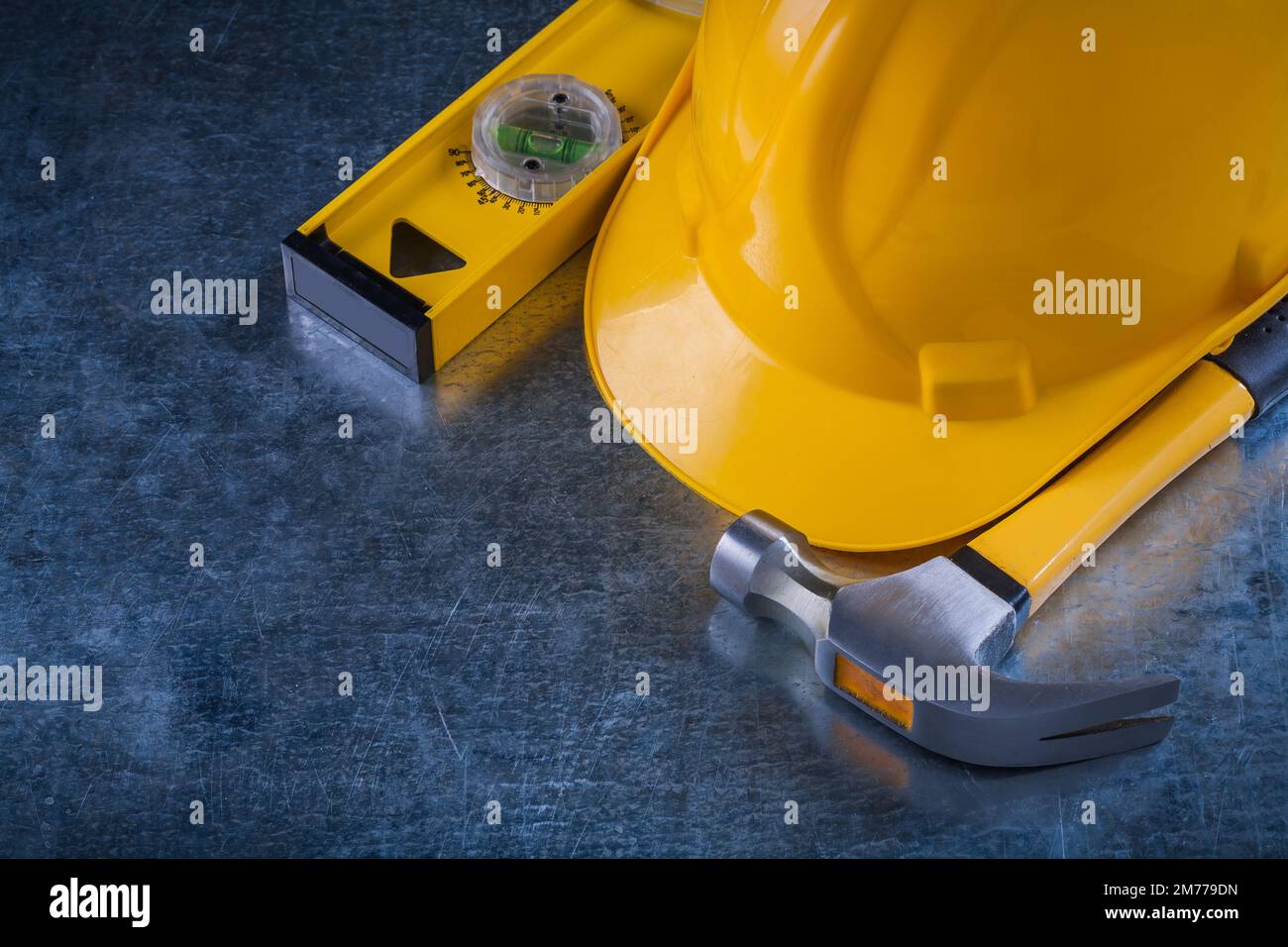 Claw hammer construction level and protective hard hat on scratched
