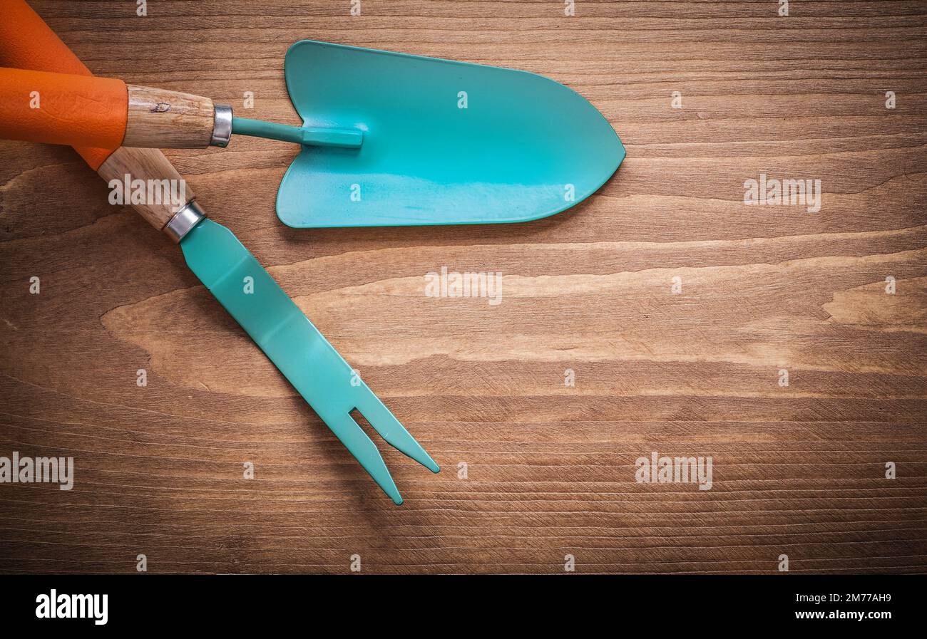 Metal root weeder hand trowel on wood board agriculture concept Stock