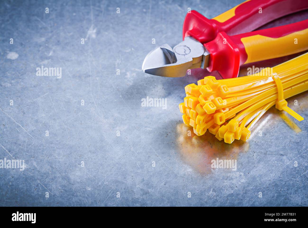 Nippers plastic zip cable ties on metallic background construction concept. Stock Photo