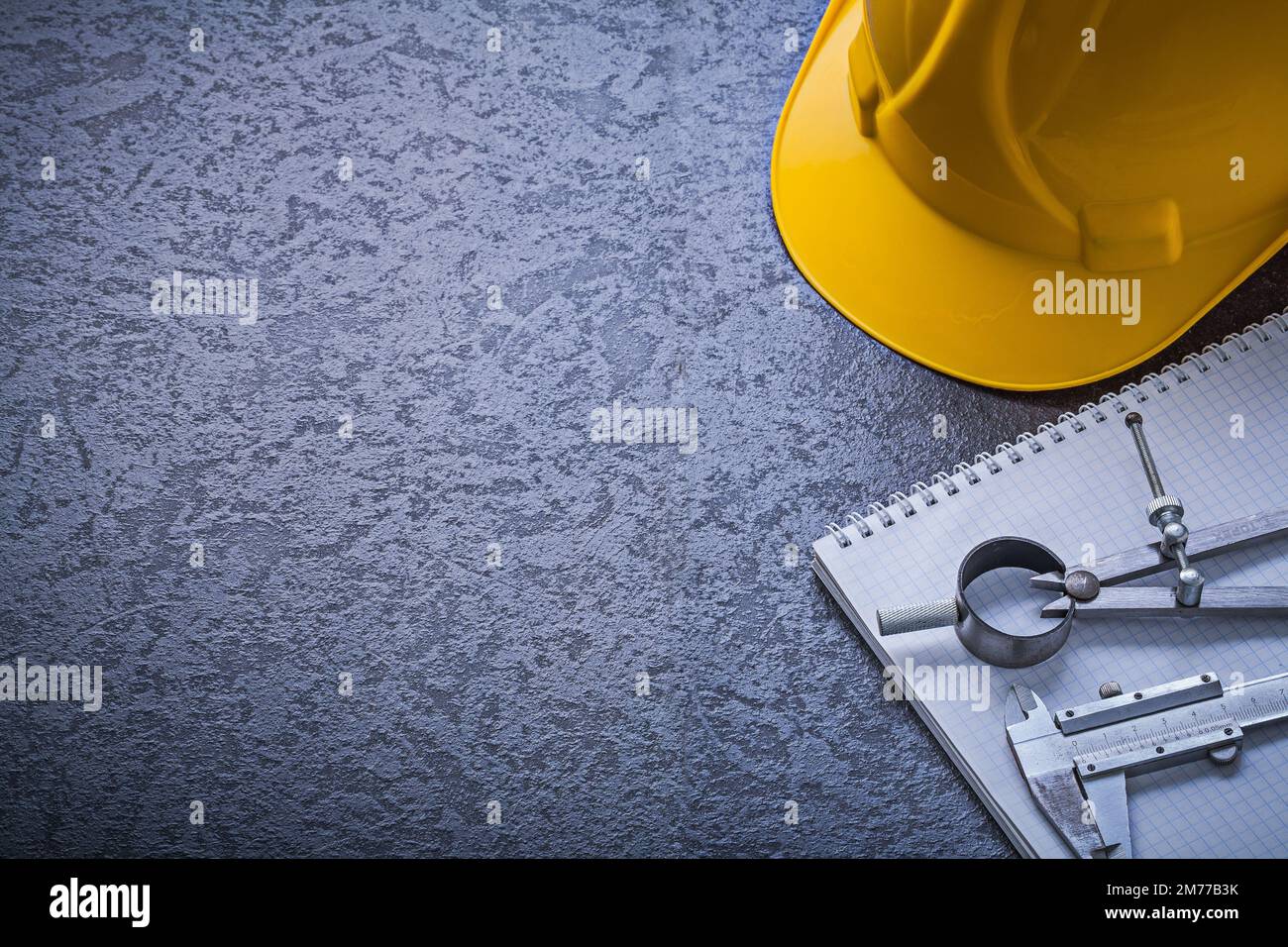 Notebook hard hat divider vernier scale copyspace construction concept. Stock Photo