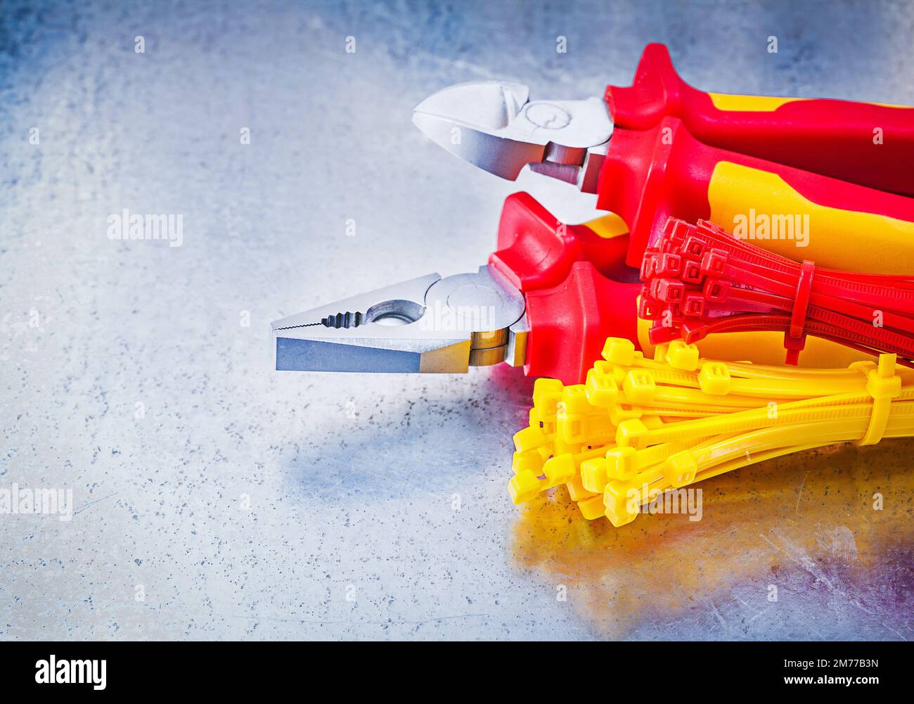 Nippers pliers self-locking cable ties on metallic background construction concept. Stock Photo