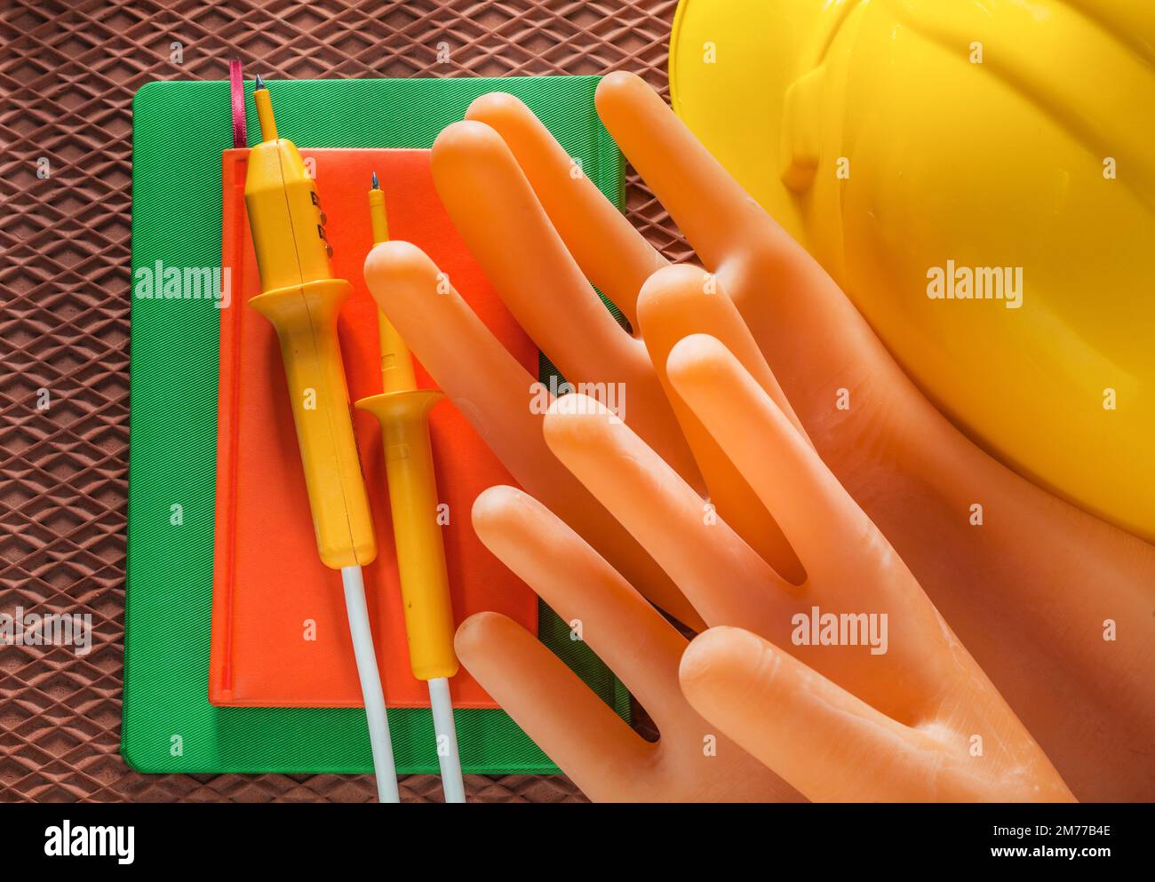 Notepad building helmet electricians gloves electrical tester on