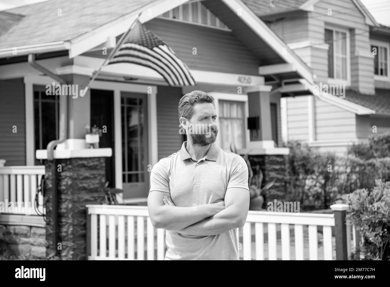 bearded man broker selling or renting house with american flag, home Stock Photo