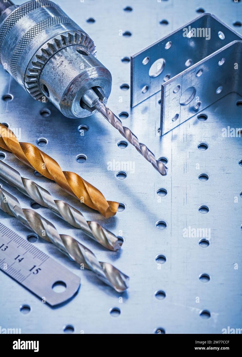 Perforated angle fasteners metal ruler drill and bits on metallic ...