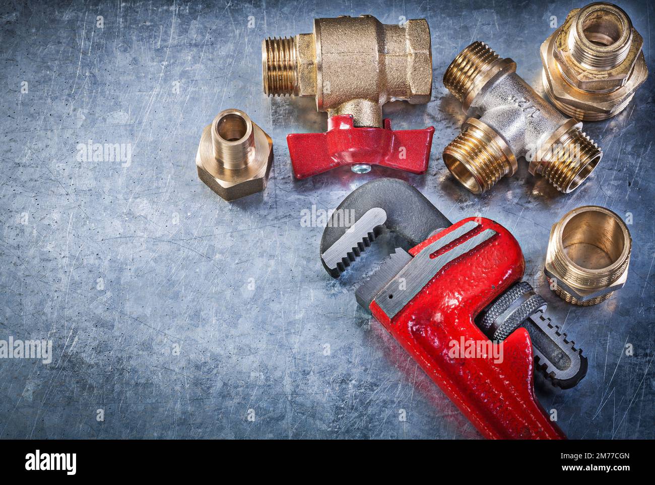 Pipe wrench brass plumbing fittings gate valve on scratched metallic ...