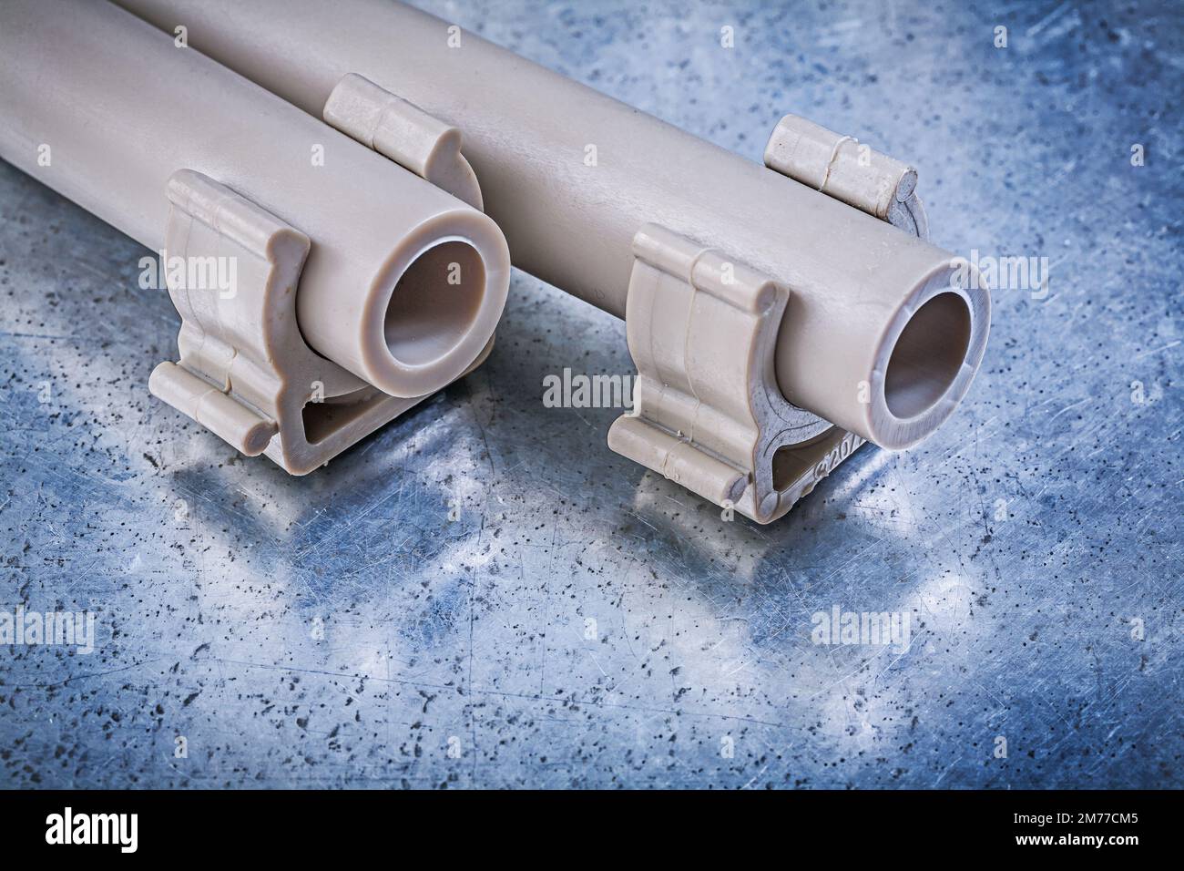 Plastic waterpipes pipe clamps on metallic background construction