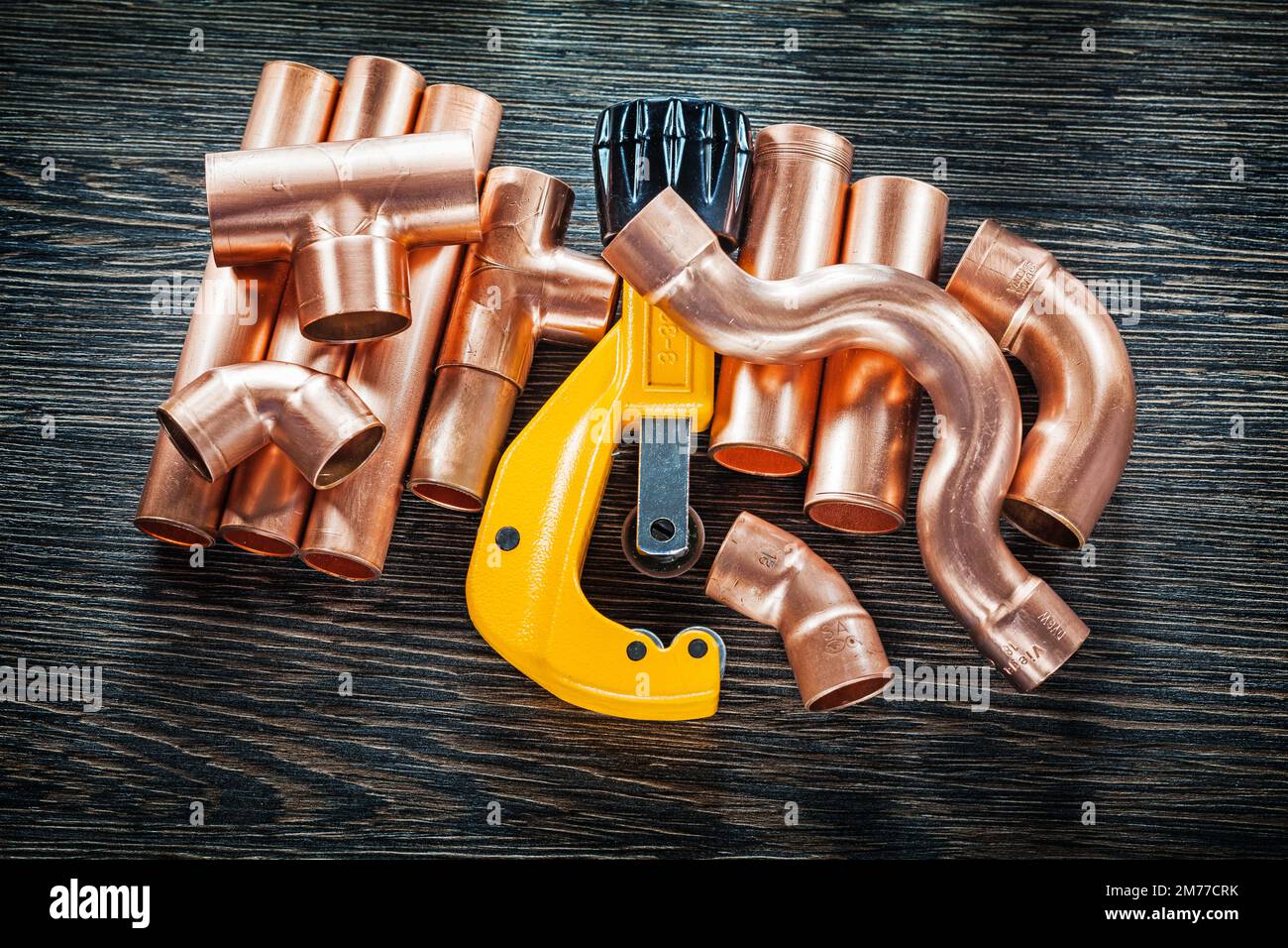 Plumbing copper water pipe cutter on wooden board. Stock Photo