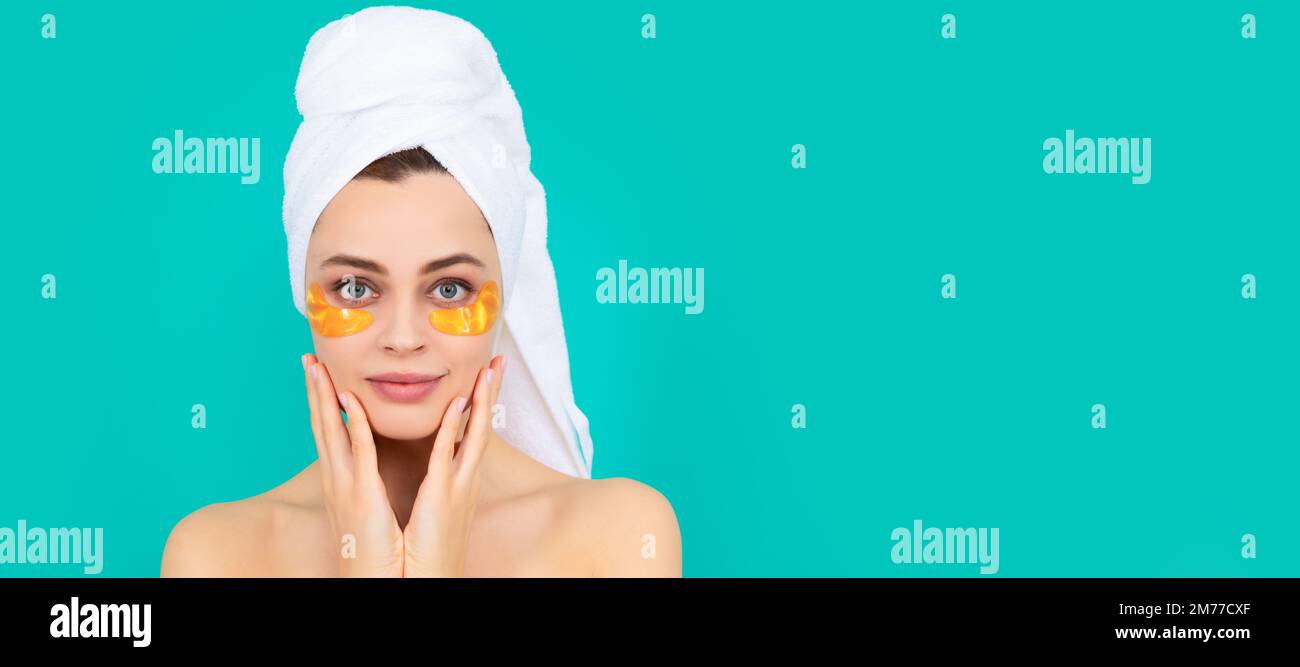 Eye patch. young girl has collagen gold eye patches on face with towel. Beautiful woman isolated face portrait, banner with mock up copy space. Stock Photo
