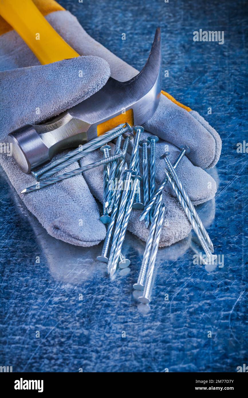 Protective glove variety of construction nails and claw hammer on
