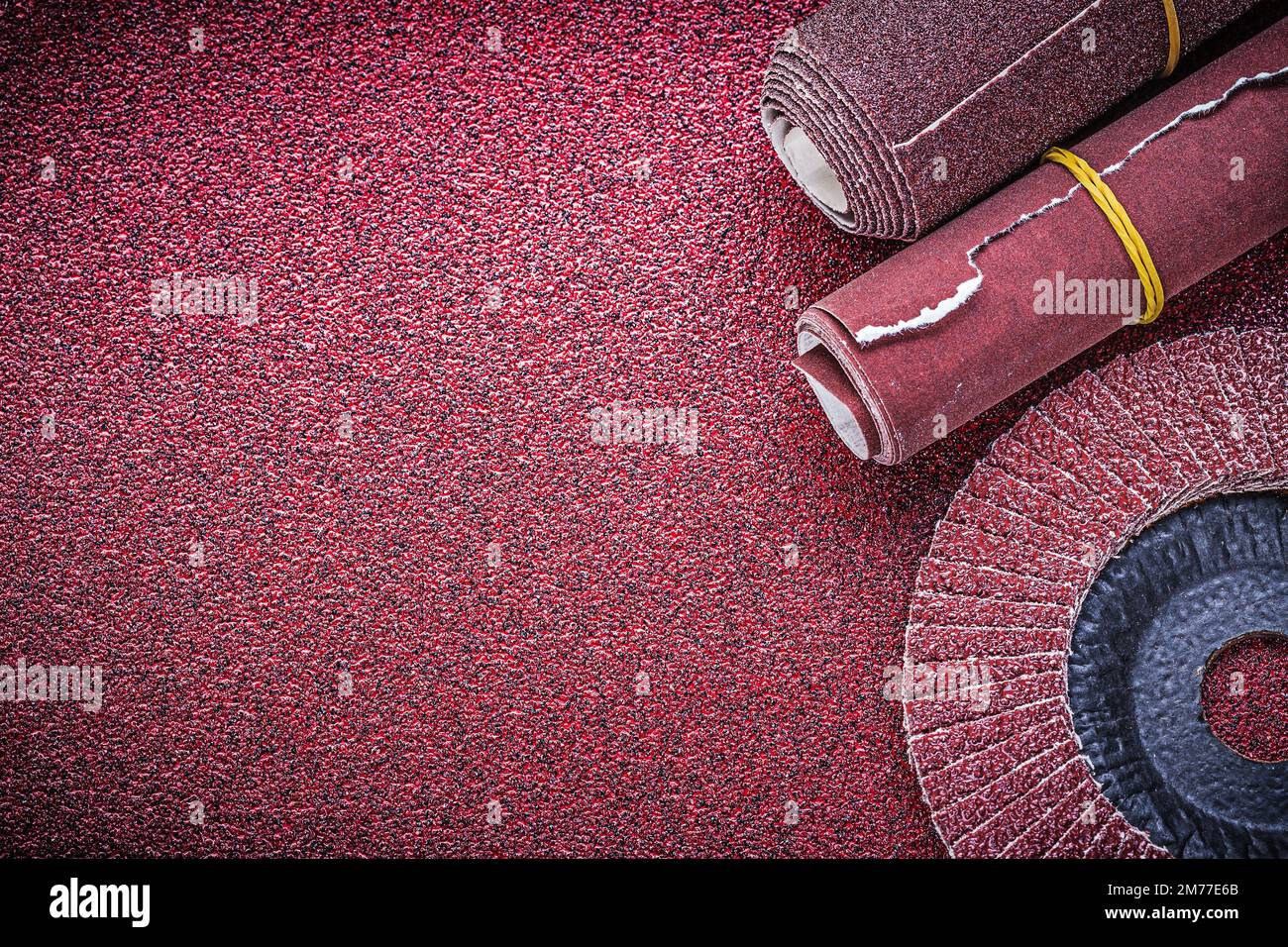 Rolled up glasspaper flap grinding wheel on abrasive sheet Stock Photo
