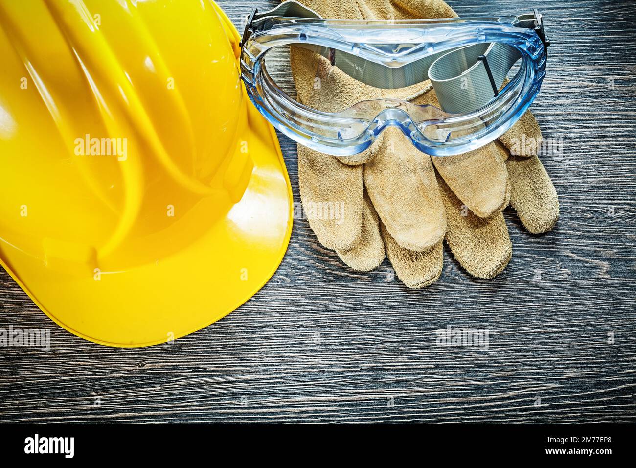 Safety goggles hard hat on wooden board. Stock Photo