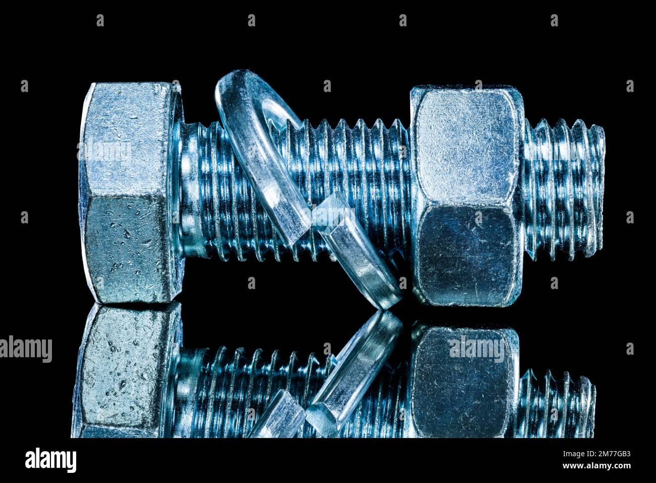 Stainless nut screwbolt spring washer on black surface. Stock Photo