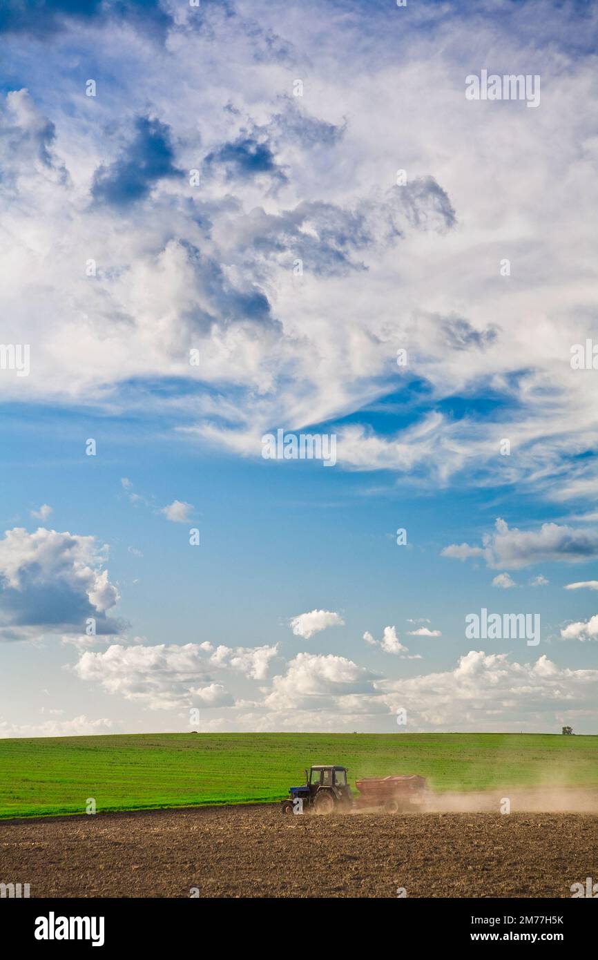 tractor on dusty spring field Stock Photo - Alamy