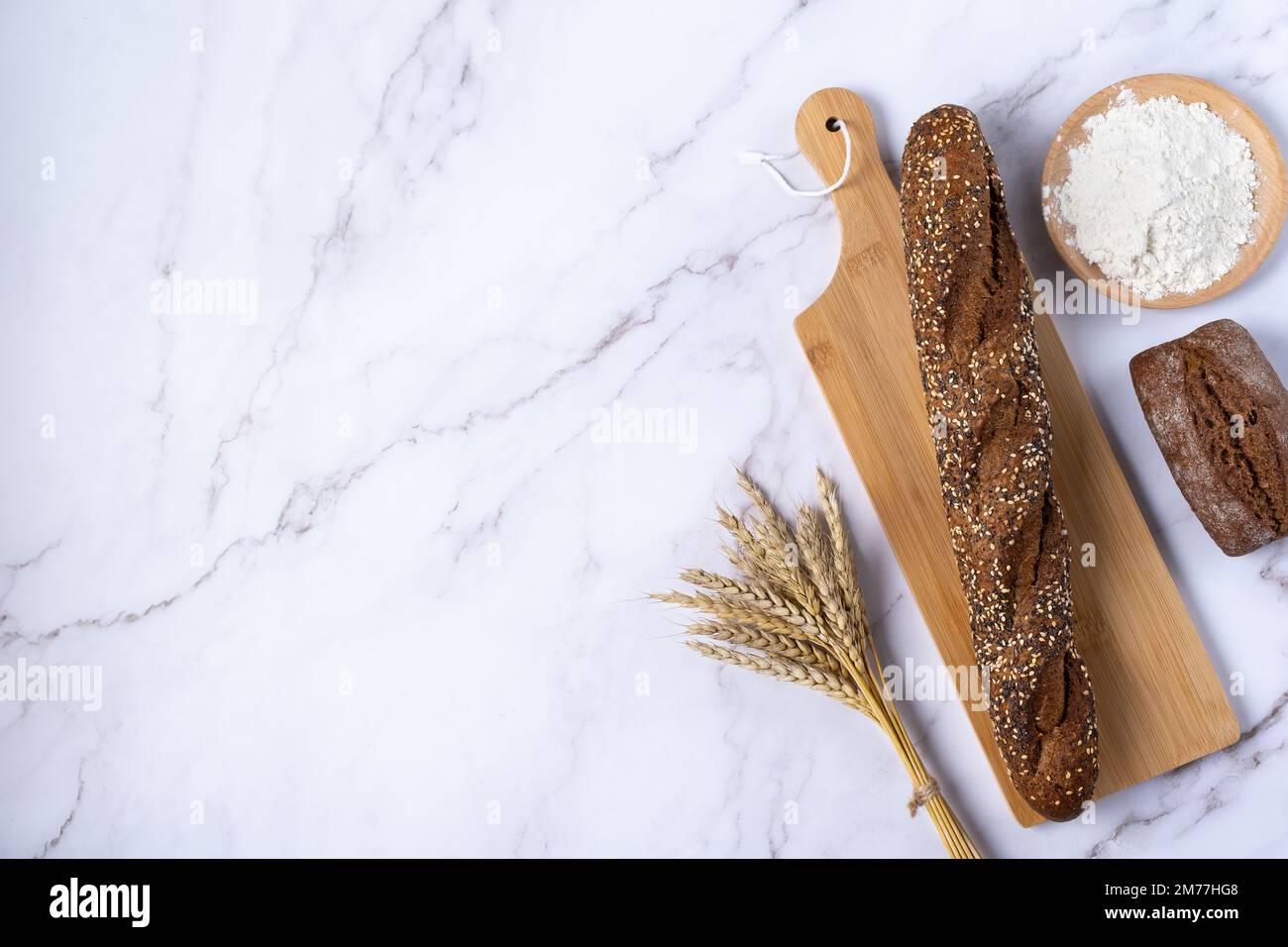 Rustic bread roll or french baguette, wheat and flour on a light background Stock Photo Alamy