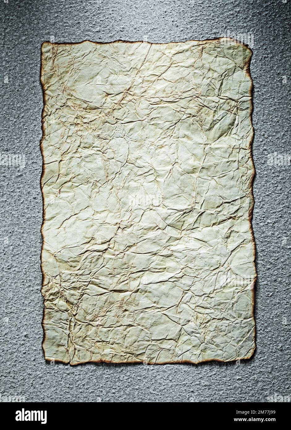 Vintage crumpled paper sheet on grey background. Stock Photo