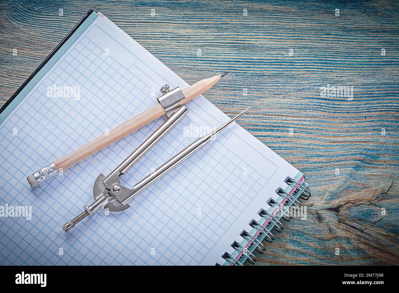 Vintage pair of compasses pencil open blank copybook on wooden board construction concept. Stock Photo