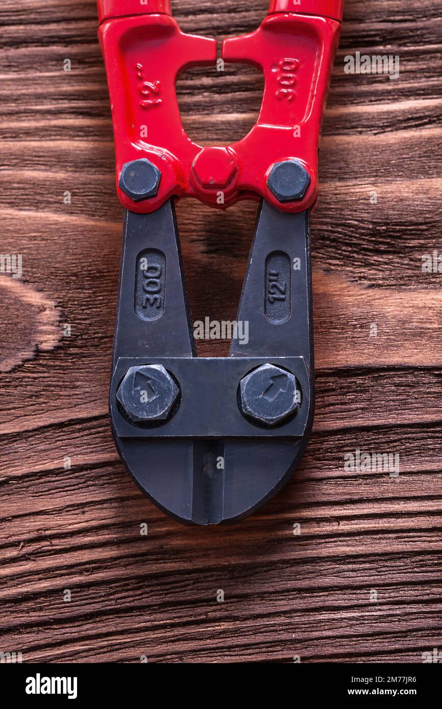 Vintage wood board with black and red bolt cutter maintenance concept