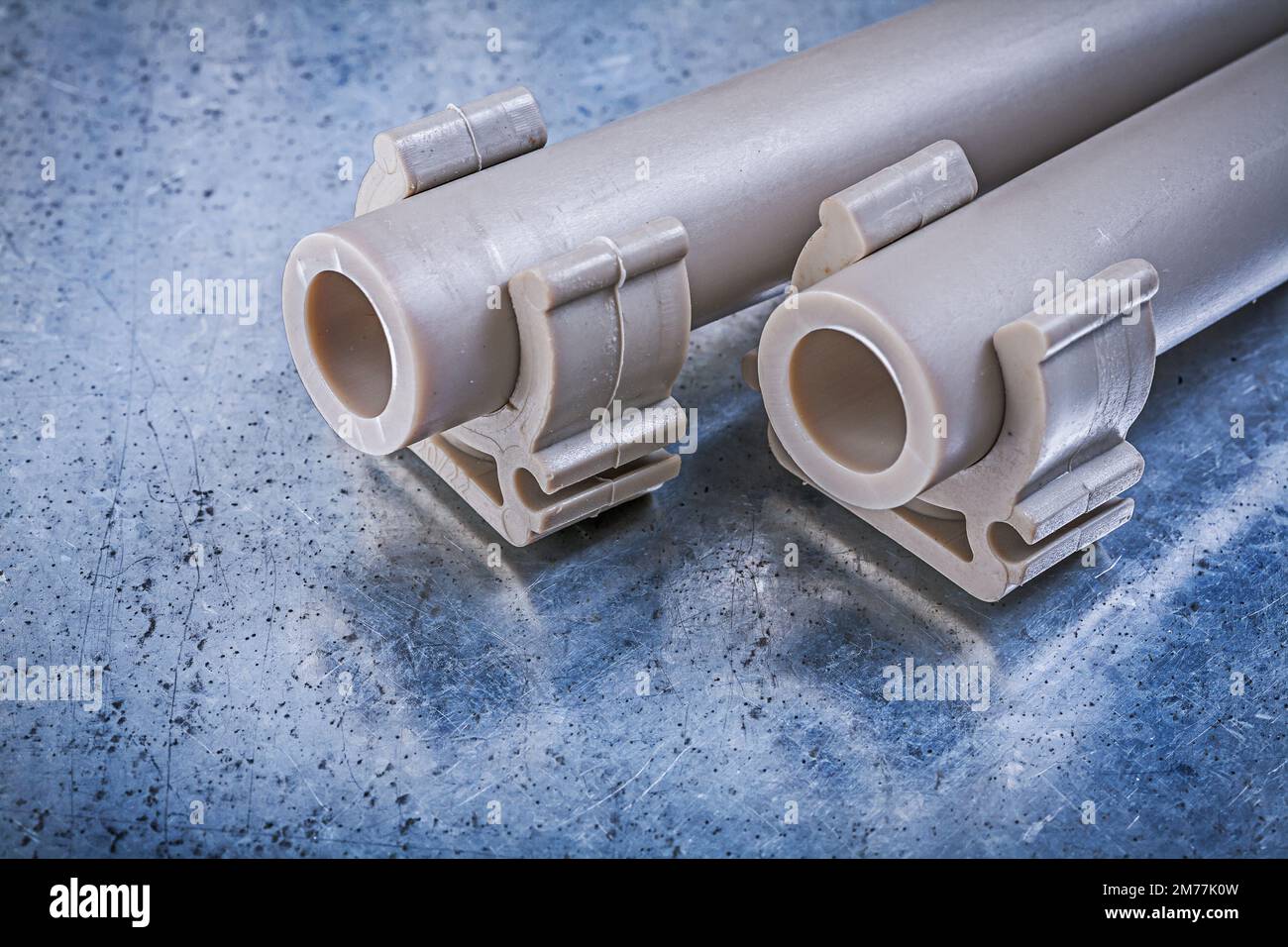 Waterpipes pipe clamps on metallic background construction concept