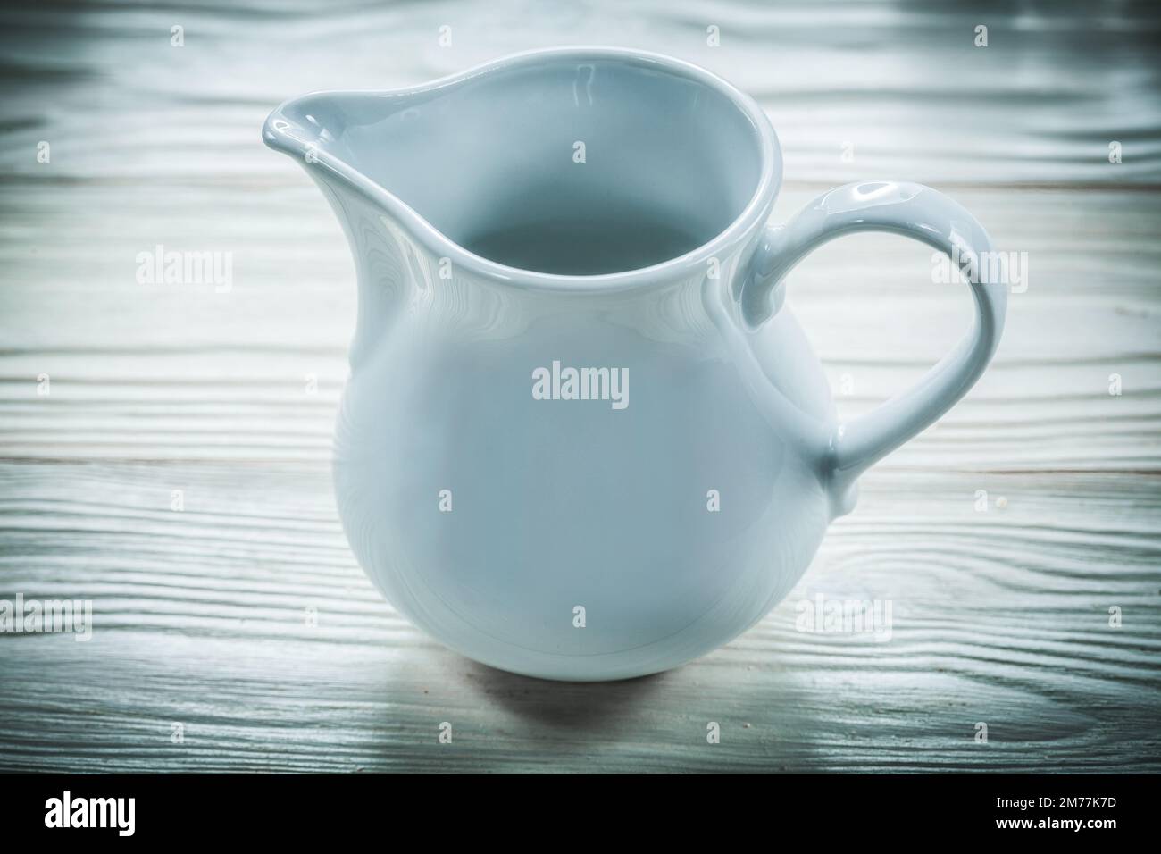 a white ceramic milk pot on a white background Stock Photo - Alamy