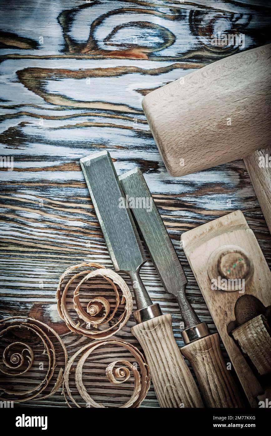 Wooden hammer chisels planer curled shavings on wood board. Stock Photo