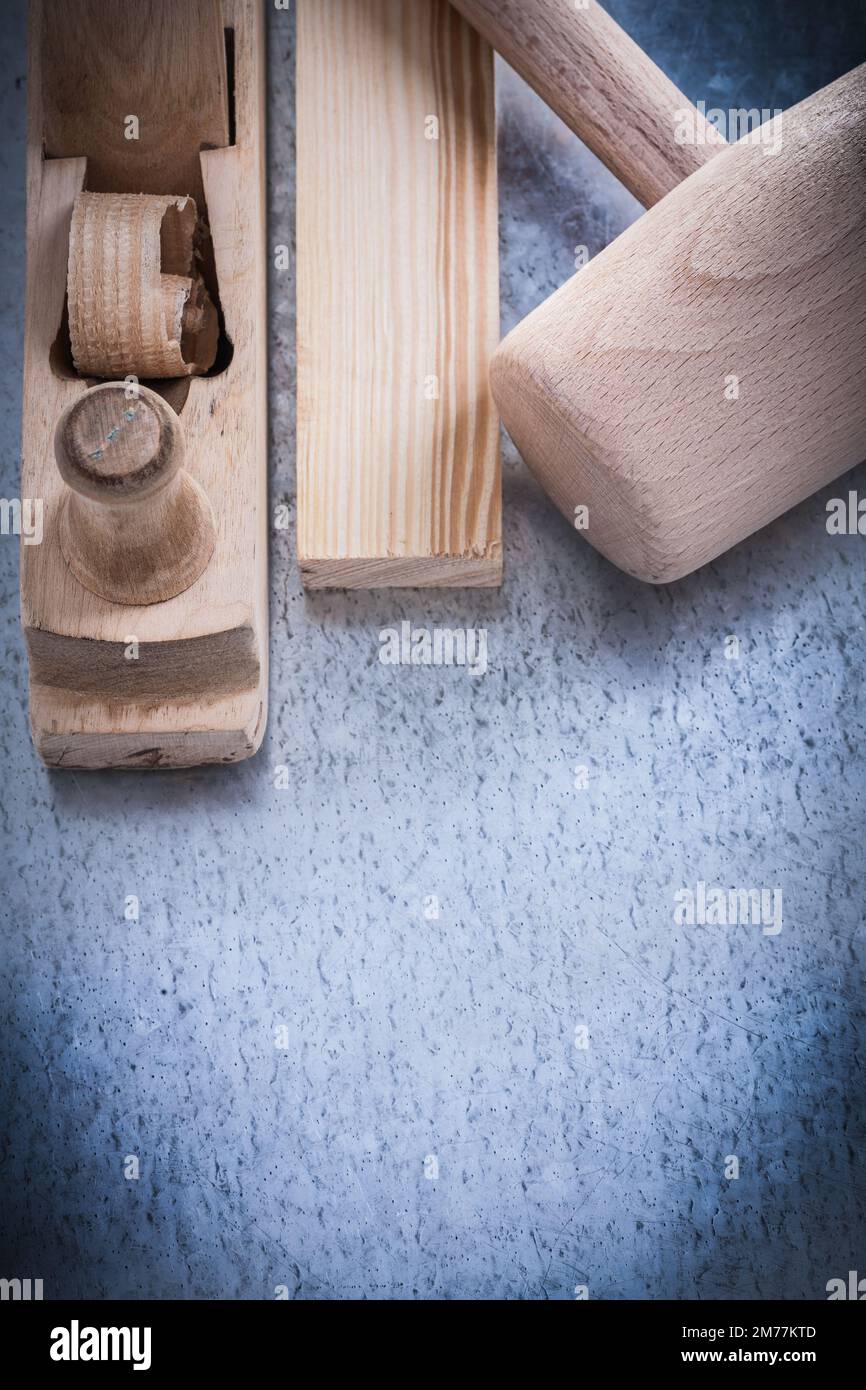 Wooden shaving plane hammer stud on metallic background construction concept. Stock Photo